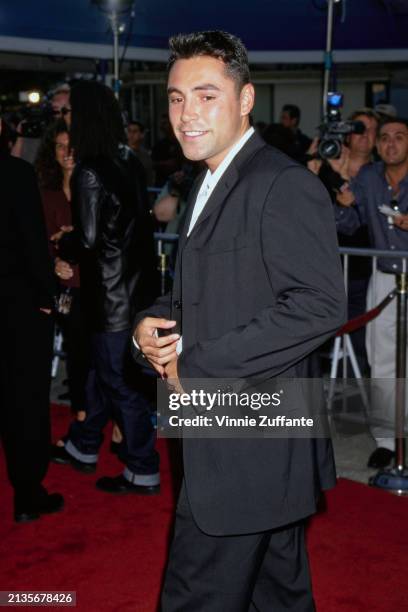 Mexican-American boxer Oscar De La Hoya, wearing a black suit over a white shirt, attends the Westwood premiere of 'Wild Wild West', at the Mann...