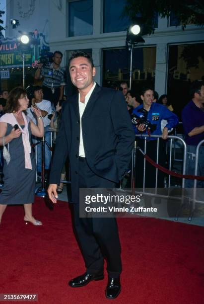 Mexican-American boxer Oscar De La Hoya, wearing a black suit over a white shirt, attends the Westwood premiere of 'Wild Wild West', at the Mann...
