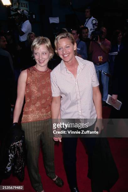 American actress Anne Heche, wearing a peach-coloured sleeveless jewel neck top with gold trim and green striped trousers, and American television...