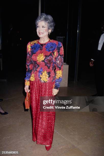 American actress and singer Gloria DeHaven, wearing a red outfit with floral motifs, attends the 10th Annual American Cinema Awards, at the Beverly...