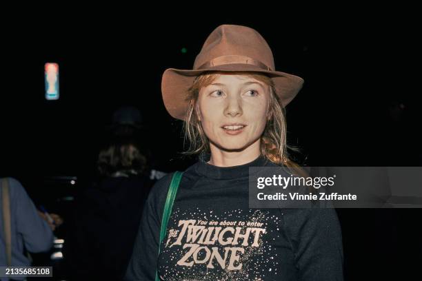 American actress Rebecca De Mornay, wearing a black sweatshirt with 'You Are About to Enter The Twilight Zone' on the chest, a brown fedora, and a...