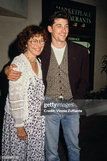 American actress Rochelle 'Rocky' Parker, wearing a white macrame cardigan over a blue-and-white floral pattern dress, and her husband, American...