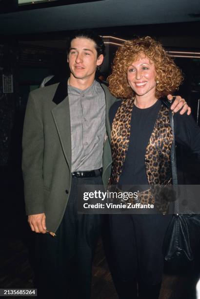 American actor Patrick Dempsey wearing a grey jacket with a black collar over a grey shirt, his left arm around his wife, American actress Rochelle...