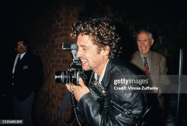 American actor Patrick Dempsey, who wears a leather jacket, holds a Canon SLR camera, at the West Hollywood premiere of 'With Honors', at the DGA...