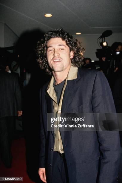 American actor Patrick Dempsey, wearing a black jacket with a khaki wide-collar shirt over a black t-shirt, attends the Westwood premiere of...