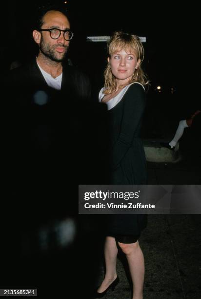 American screenwriter and author Bruce Wagner, wearing a black suit, and his wife, American actress Rebecca De Mornay, who wears a black dress with a...