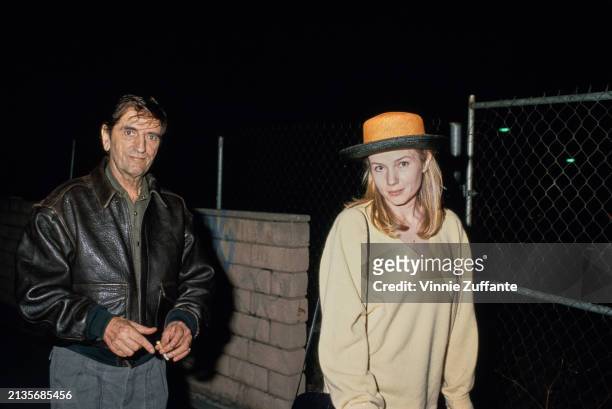 American actor Harry Dean Stanton, wearing a leather jacket over a grey shirt, and American actress Rebecca De Mornay, who wears a pale yellow...
