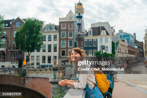 Mujer alegre caminando en Amsterdam en verano Mujer alegre caminando en Amsterdam en verano