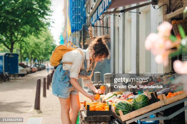 femme achetant des fruits dans une petite boutique à amsterdam - marches photos et images de collection