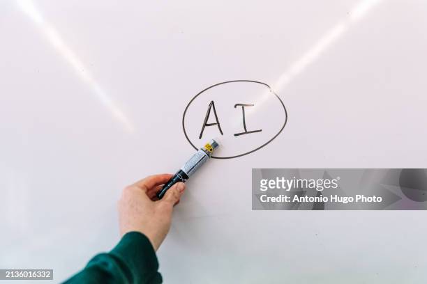 man's hand showing a blackboard with artificial intelligence written on it. - one empty desk stock pictures, royalty-free photos & images