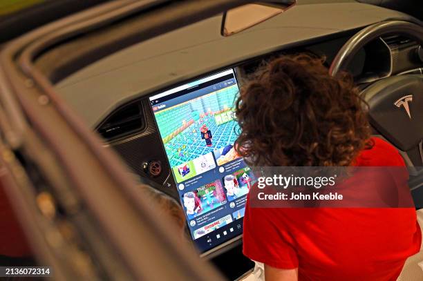 Young child watches youtube gaming videos on the Tesla front touchscreen during the Everything Electric London 2024 at ExCel on March 28, 2024 in...