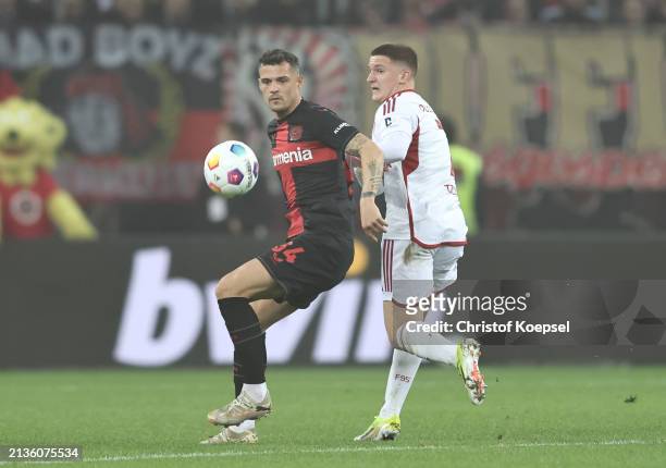 Granit Xhaka of Bayer Leverkusen holds off Christos Tzolis of Fortuna Duesseldorf during the DFB cup semifinal match between Bayer 04 Leverkusen and...