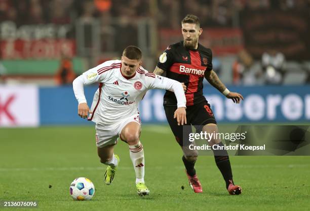 Christos Tzolis of Fortuna Duesseldorf chases the ball whilst under pressure from Robert Andrich of Bayer Leverkusen during the DFB cup semifinal...