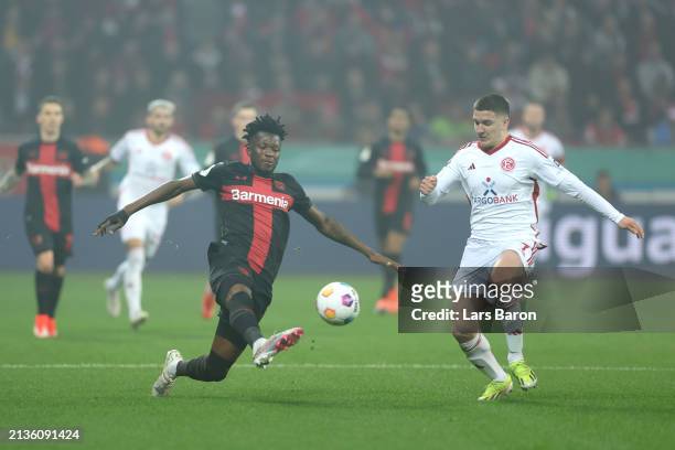 Edmond Tapsoba of Bayer Leverkusen controls the ball whilst under pressure from Christos Tzolis of Fortuna Duesseldorf during the DFB cup semifinal...
