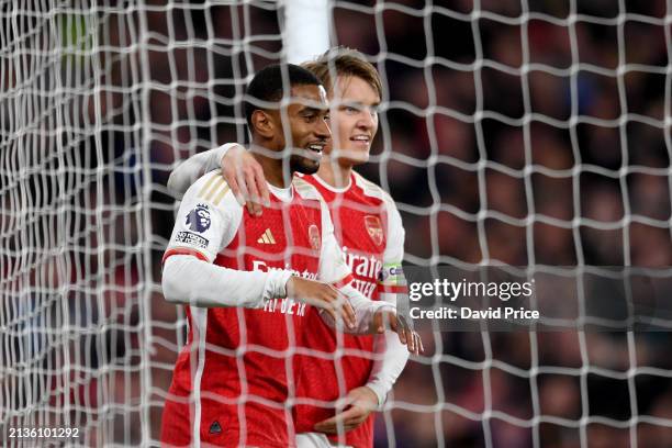 Reiss Nelson of Arsenal celebrates his team's second goal with teammate Martin Odegaard, an own goal scored by Daiki Hashioka of Luton Town during...