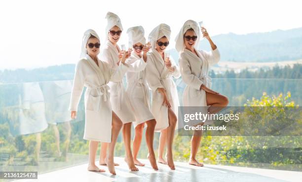 freundinnen in weißen bademänteln vor einem junggesellinnenabschied stoßen mit champagner an - junggesellinnenabschied stock-fotos und bilder