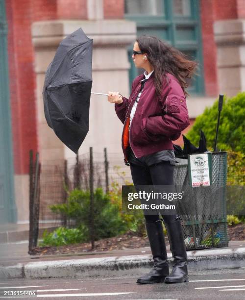 Irina Shayk is seen with her umbrella getting blown by the wind on April 03, 2024 in New York City.