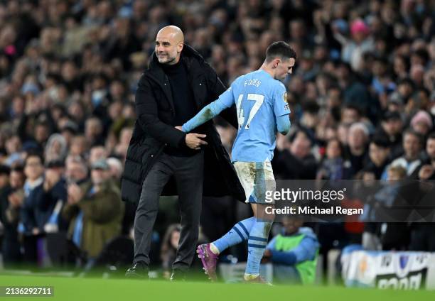 Pep Guardiola, Manager of Manchester City, interacts with his player, Phil Foden as he is substituted during the Premier League match between...