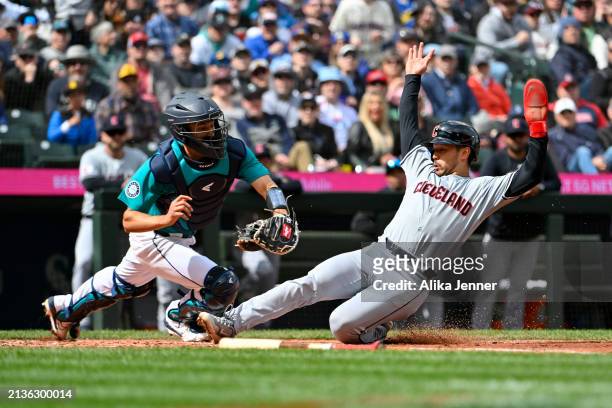 Steven Kwan of the Cleveland Guardians is beats the tag at home plate by Seby Zavala of the Seattle Mariners during the second inning at T-Mobile...