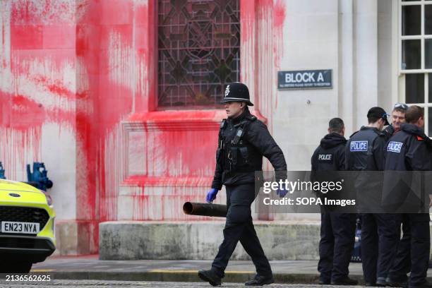 Police officer walks away with one of the protester's lock-ons during a demonstration outside Somerset County Hall. Supporters of Palestine Action...