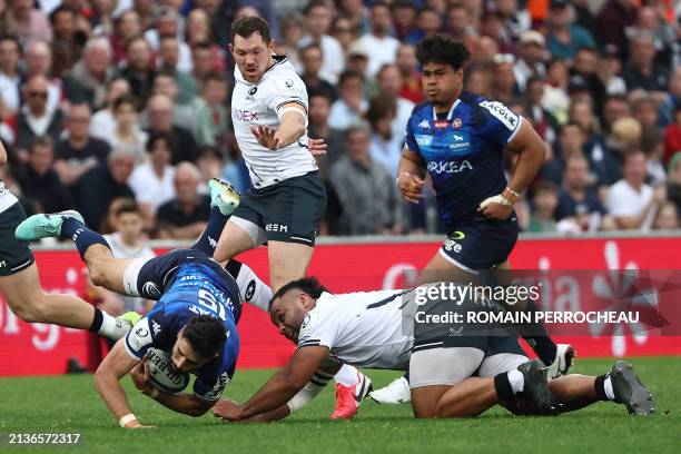 Bordeaux' French fullback Romain Buros is tackled by Saracens' English N8 Billy Vunipola during the European Rugby Champions Cup round of 16 rugby...