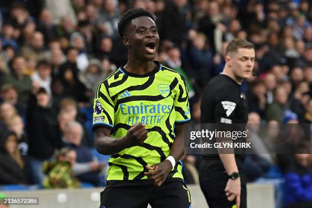 Arsenal's English midfielder Bukayo Saka celebrates after scoring the opening goal from the penalty spot during the English Premier League football...