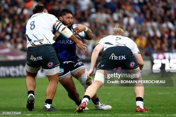 Bordeaux' New Zealander prop Benjamin Tameifuna is tackled by Saracens' English N8 Billy Vunipola and Saracens' English lock Hugh Tizard during the...