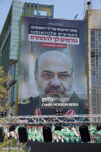 Vehicles drive past a banner showing a portrait of the late Iranian Revolutionary Guard Gen. Mohammad Reza Zahedi who was killed in an airstrike...