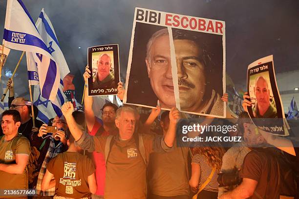 Relatives and supporters of Israeli hostages held in Gaza since the October 7 attacks by Hamas militants hold pictures of 47-year-old hostage Elad...