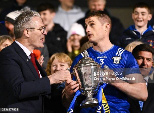 Tipperary , Ireland - 6 April 2024; Uachtarán Chumann Lúthchleas Gael Jarlath Burns presents the Clare captain Conor Cleary with the trophy after the...