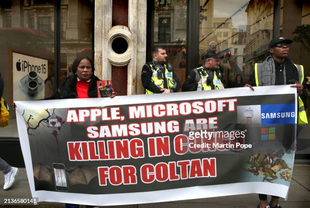 Protesters hold a banner saying ' Apple, Microsoft, Samsung Killing in Congo for Coltan' outside the Apple Store during the demonstration on April 6,...