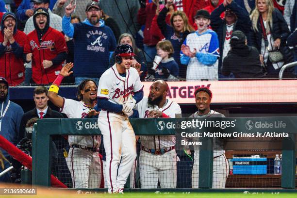 Jarred Kelenic celebrates with Ronald Acuña Jr. #13, Raisel Iglesias, Marcell Ozuna, and Ozzie Albies of the Atlanta Braves after tying the game in...