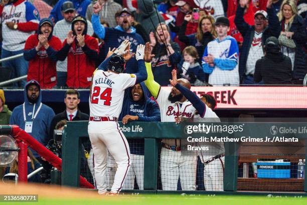 Jarred Kelenic celebrates with Raisel Iglesias, Marcell Ozuna, and Ozzie Albies of the Atlanta Braves after tying the game in the ninth inning...