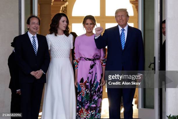 Republican presidential candidate and former US President Donald Trump and former first lady Melania Trump arrive at the home of John Paulson with...