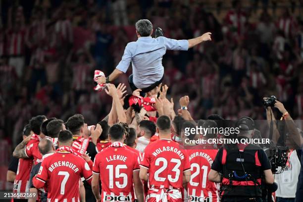 Athletic Bilbao's Spanish coach Ernesto Valverde is tossed in the air by players to celebrate their victory at the end of the Spanish Copa del Rey...