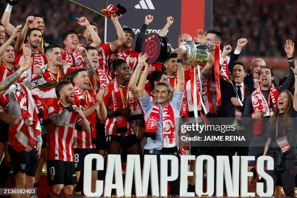 Athletic Bilbao's Spanish coach Ernesto Valverde holds the Copa del Rey trophy at the end of the Spanish Copa del Rey final football match between...