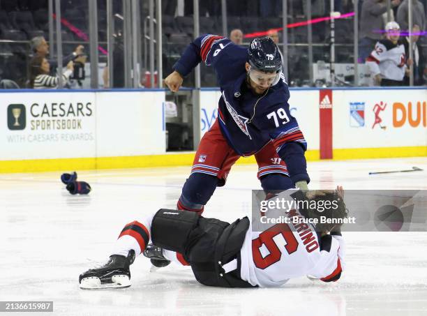 Andre Miller of the New York Rangers fights with John Marino of the New Jersey Devils during the first period at Madison Square Garden on April 03,...
