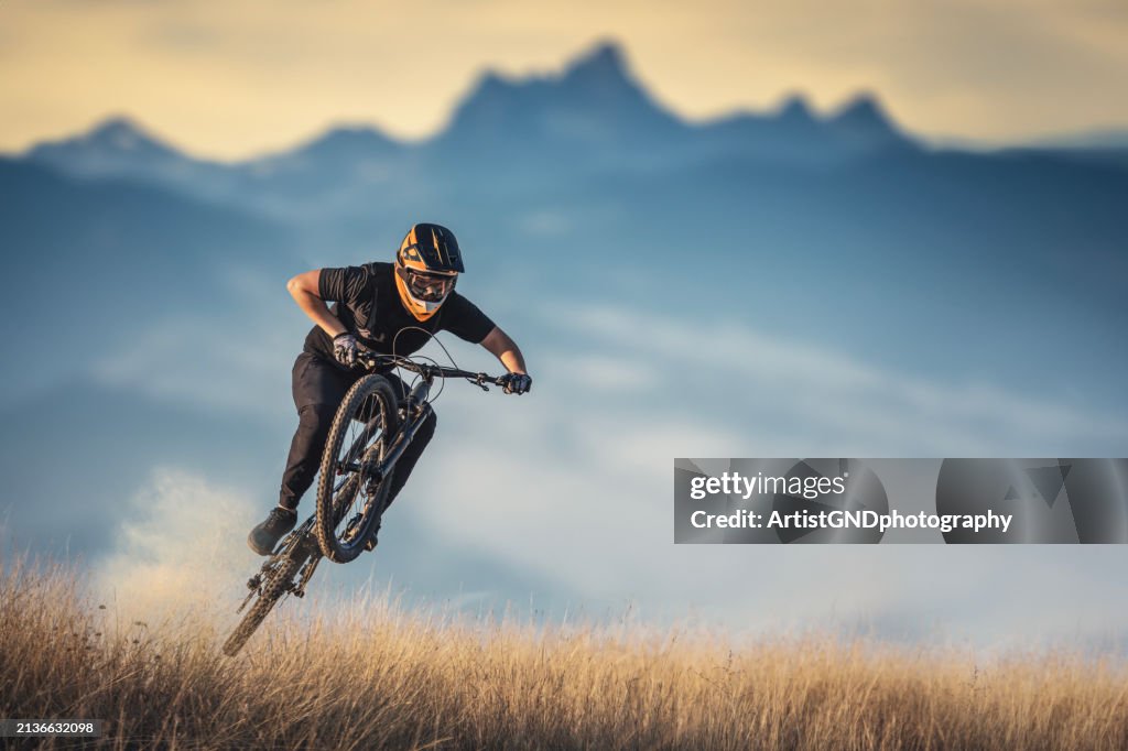 El ciclista de montaña está saltando en el sendero de las montañas.