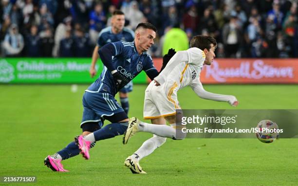 Riqui Puig of LA Galaxy is pursued by Erik Thommy of Sporting Kansas City in midfield during a game between Los Angeles Galaxy and Sporting Kansas...
