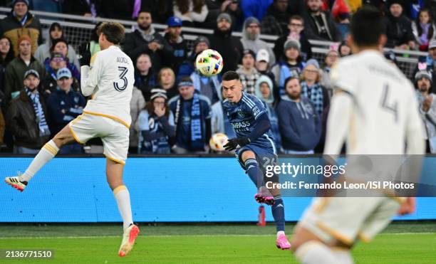 Erik Thommy of Sporting Kansas City crosses the ball into the box as Julian Aude of LA Galaxy throws his body in the way during a game between Los...