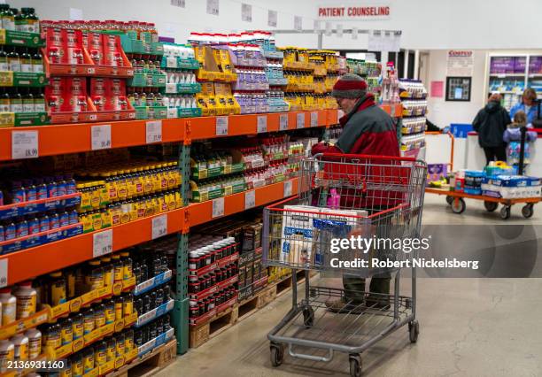 Man checks the label of a vitamins jar at a Costco Wholesale store on April 3, 2024 in Colchester, Vermont.
