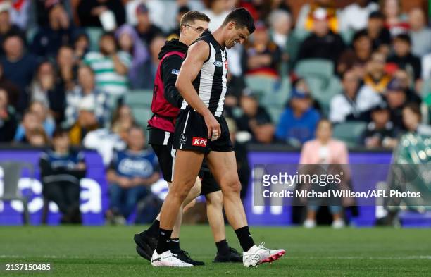 Scott Pendlebury of the Magpies speaks with medical staff during the 2024 AFL Round 04 match between the Collingwood Magpies and the Hawthorn Hawks...