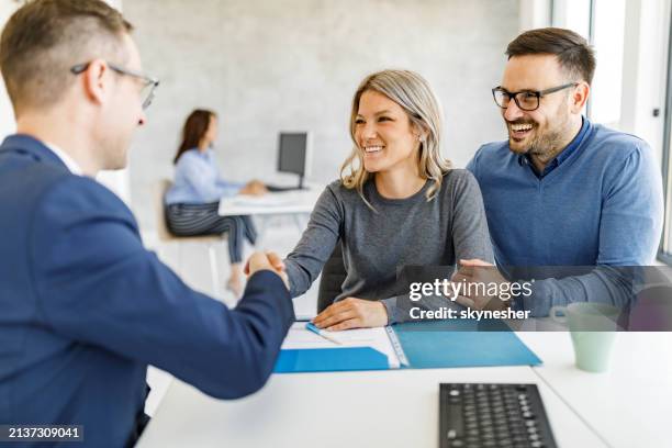 glückliches paar kam zu einer vereinbarung mit ihrem finanzberater im büro. - bankdirektor stock-fotos und bilder