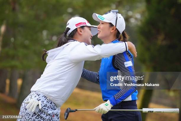 Yuting Seki of China and Rei Matsuda of Japan embrace after holing out on the 18th green during the first round of YANMAR HANASAKA Ladies Golf...