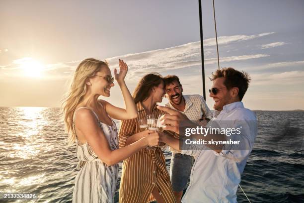 parejas alegres brindando en un día de verano en un barco al atardecer. - navegación en yate fotografías e imágenes de stock
