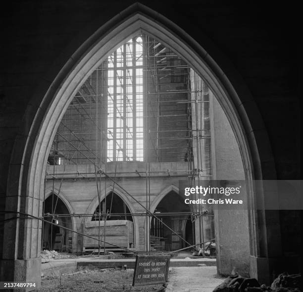 Interior view of Guildford Cathedral during construction, January 1949. Seen from an arch are the building's south porch and a tall window above. A...