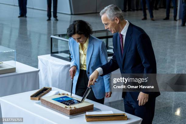 Secretary General Jens Stoltenberg and Belgian Foreign Minister Hadja Lahbib cut a commemorative cake during the alliance's 75th anniversary...