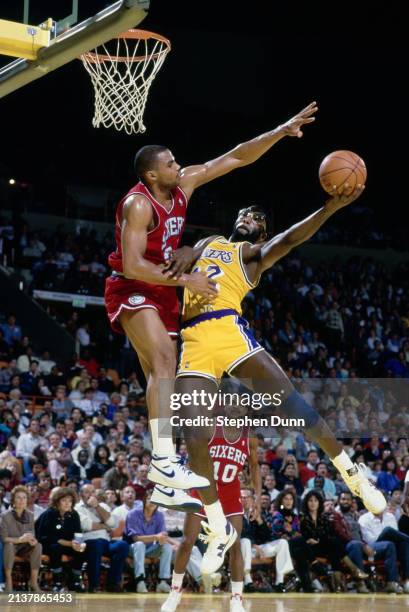 James Worthy, Small Forward and Power Forward for the Los Angeles Lakers drives to the basket to make a layup shot as Charles Barkley, Power Forward...
