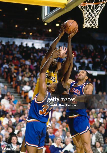 James Worthy, Small Forward and Power Forward for the Los Angeles Lakers drives to the basket as Henry James and Larry Nance, Power Forwards for the...