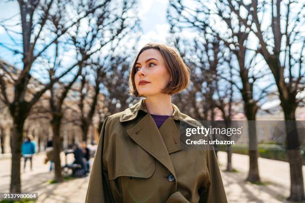 young woman walking in the park in paris in france - casaco florido imagens e fotografias de stock